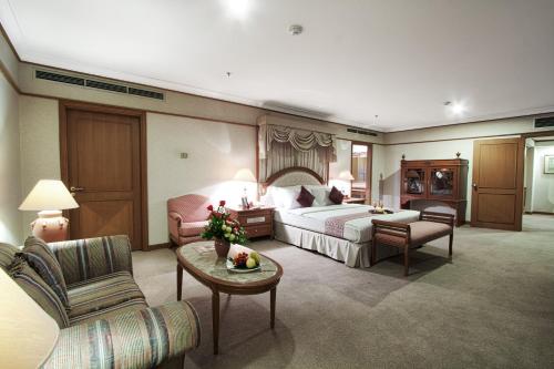 a large hotel room with a bed and a couch at Hotel Sahid Jaya Solo in Solo