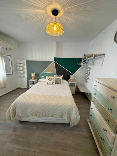 a bedroom with a large bed and a dresser at Casa el Nio in Jimena de la Frontera