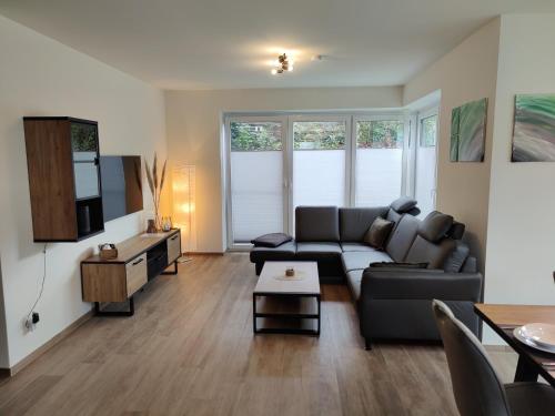 a living room with a couch and a tv at Haus Albatros EG - Exklusive Fewo für 4 Personen in Dangast