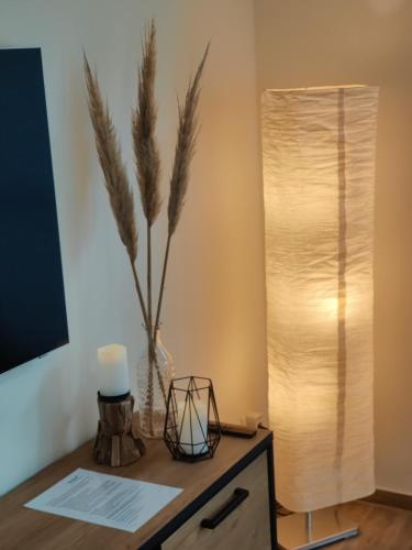 a table with a lamp and a vase with a plant at Haus Albatros EG - Exklusive Fewo für 4 Personen in Dangast