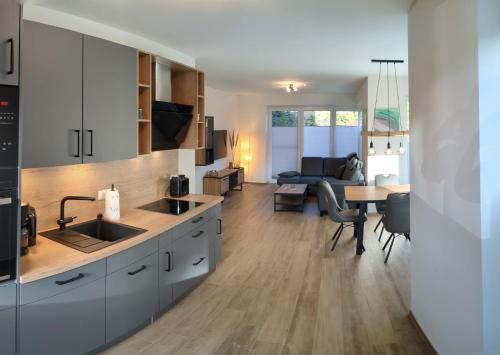Una cocina con gabinetes blancos y una sala de estar. en Haus Albatros EG - Exklusive Fewo für 4 Personen, en Dangast