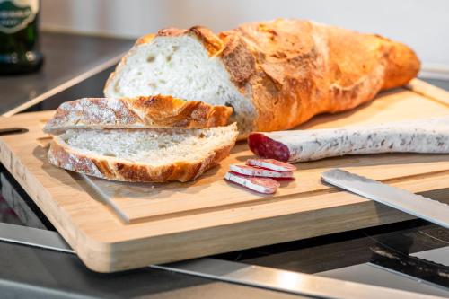 a loaf of bread sitting on a cutting board with a knife at LIVINGLike-Apartment - Central & Spacious with Balkony & Garage, Coffee - 103m2 in Pforzheim