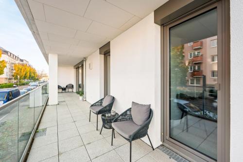 a balcony with chairs and a view of a street at LIVINGLike-Apartment - Central & Spacious with Balkony & Garage, Coffee - 103m2 in Pforzheim