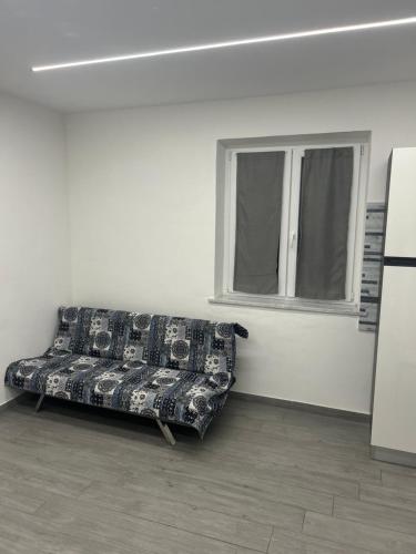 a couch sitting in a room with a window at Appartamento Tortona in Tortona