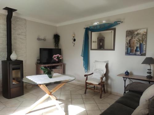 a living room with a couch and a table at Maison au milieu des vignes in Vacqueyras