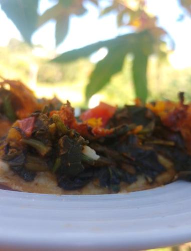 a close up of a pizza on a white plate at Vanista Dica- Dancing Bamboo in Isle
