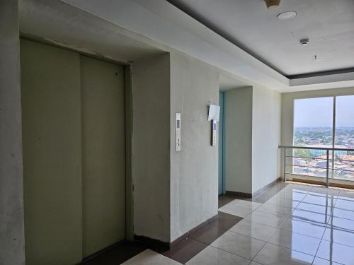 a elevator in a room with a window at Apartemen Green Lake View Ciputat by Twin Property in Pondokcabe Hilir