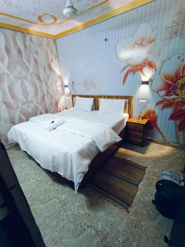 a bedroom with a large bed in a room with a mural at Milestone Homestay Agra in Tājganj