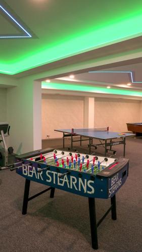 two ping pong tables in a room with green lights at Prenoćište Srebrno Jezero in Veliko Gradište