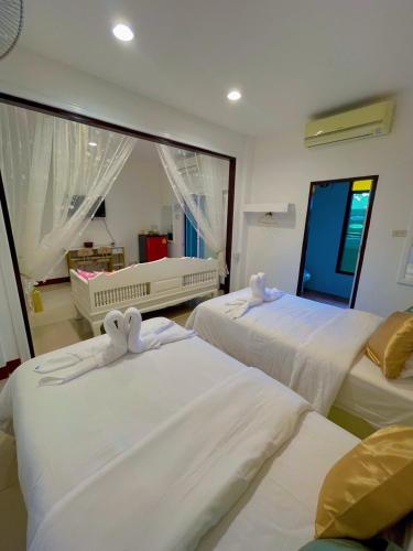 a bedroom with three beds and a large window at ฝ้ายคำ บูธีค เชียงใหม่ in Chiang Mai