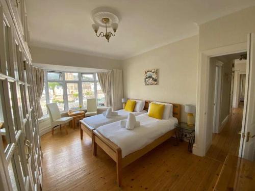 a bedroom with a large white bed with yellow pillows at MarinaSeaView-4Br-8Guests-FreeParking-PetsFriendly in Torquay