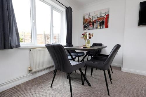 a dining room with a table and chairs and a window at Escape to Comfort 3BR in Avonmouth