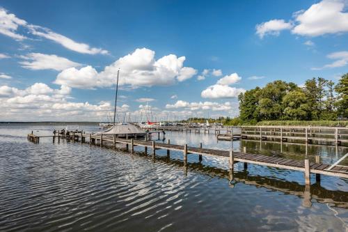 a dock with a sail boat on the water at To Huus am Steinhuder Meer in Steinhude