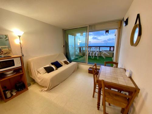 un salon avec un canapé et une table dans l'établissement Appartement idéalement situé face à l'océan, à Lacanau