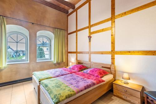 a bedroom with a wooden bed with pink pillows at Ferienwohnungen Bunge in Krostitz