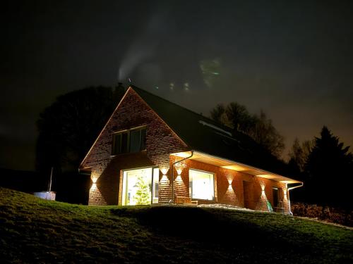 a house with lights on the side of it at night at Villa Chalet Bledule-wellness & sauna in Roprachtice