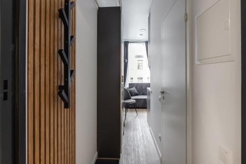 a hallway with a door and a room with a couch at Hook Studios Vilnius Old Town Economy in Vilnius