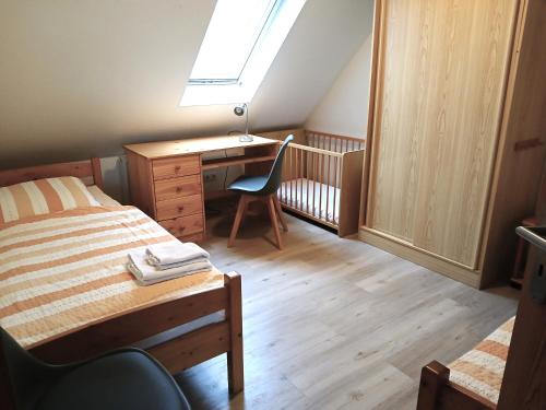 a bedroom with a desk and a bed with a chair at Ferienhof Christian und Antje Hopp in Fehmarn