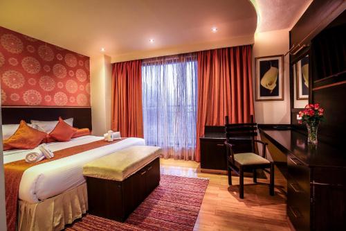 Pokój hotelowy z łóżkiem i biurkiem w obiekcie The Monarch Hotel w mieście Nairobi