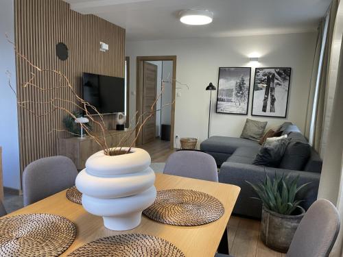 Una sala de estar con una mesa con un jarrón encima. en Apartmány Kellov Dom, en Demänovská Dolina