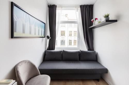 a living room with a couch and a window at Hook Studios Vilnius Old Town Economy in Vilnius