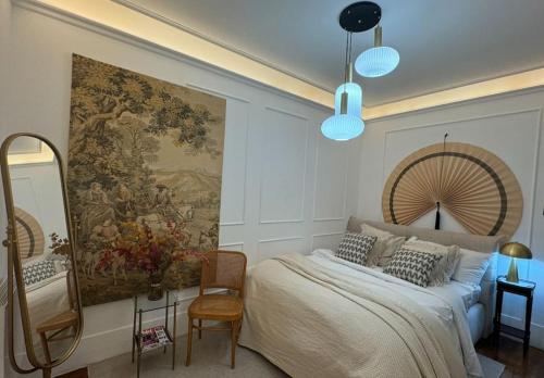 パリにあるAppartement parisien chic & cosy MBKAの壁に大きな絵が飾られ、ベッドが置かれた寝室