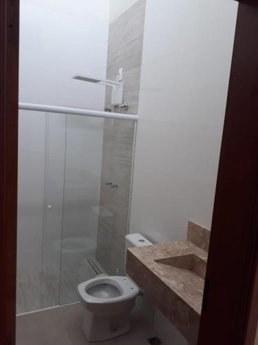 a bathroom with a toilet and a shower and a sink at Área de lazer Cantinho do Fofo in São Carlos
