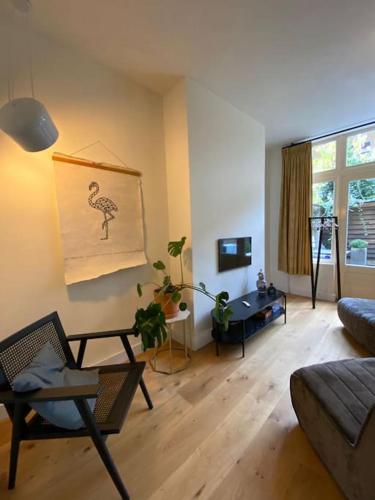 a living room with a couch and a table at Sfeervol appartement met patio in het centrum in Groningen