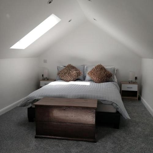 a bedroom with a bed with pillows on it at The Retreat in Chelwood Gate