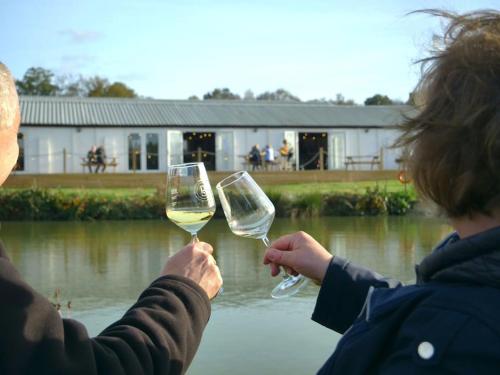two people holding up glasses of white wine at The Retreat in Chelwood Gate