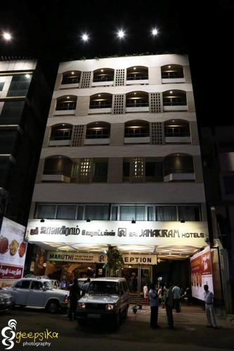 a large building with cars parked in front of it at Sri Janakiram Hotels in Tirunelveli