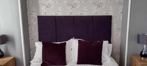 a bed with two pillows and a head board at Bluebird Lodge in Coniston