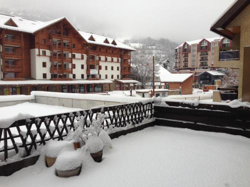 a balcony covered in snow with buildings in the background at T3 avec terrasse plein sud au pied des télécabines in Briançon