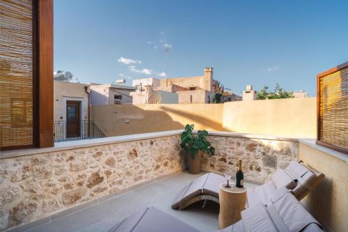 a balcony with two chairs and a table on a building at Mansio Boutique Hotel in Rethymno Town