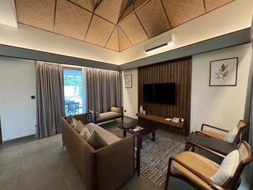 a living room with a couch and a tv at The Golkonda Resort and Spa in Hyderabad