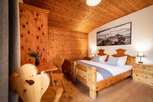 a bedroom with a bed and a table and chairs at Ferienhaus Waldwinkl in Flachau