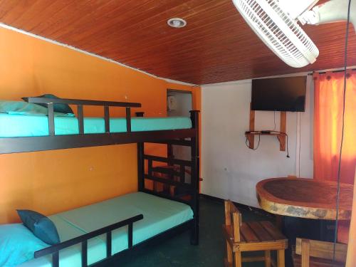 a room with two bunk beds and a table at Biohotel Caribe Green in Santa Marta