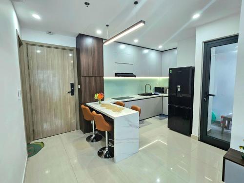 a kitchen with a white counter and a black refrigerator at T- Plus Apartment - Căn hộ 2 PN view hồ bơi in Thôn Văn Dương