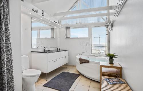 a bathroom with a tub and a sink and a toilet at Holiday Home Næsvej Iii in Assens