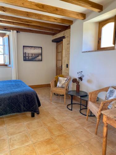a bedroom with a bed and a table and chairs at Domaine de Cazal - Chambres d'Hôtes avec piscine au cœur de 26 hectares de nature préservée in Saint-Cyprien