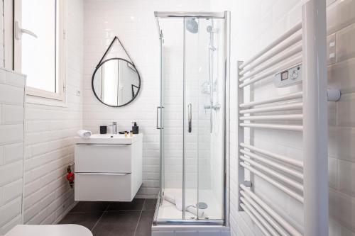 une salle de bain blanche avec une douche et un lavabo dans l'établissement 1 GAUTIER 101 - Joli studio equipe - Quartier du Port, à Nice
