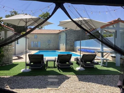 - une piscine avec 2 chaises, une table et des parasols dans l'établissement Perfect getaway for a family holiday, à Saint-Fraigne