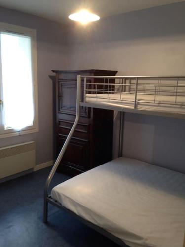 une chambre avec deux lits superposés et une fenêtre dans l'établissement F2 et JARDINET FACE ET ACCES DIRECT MER, à Bernières-sur-Mer