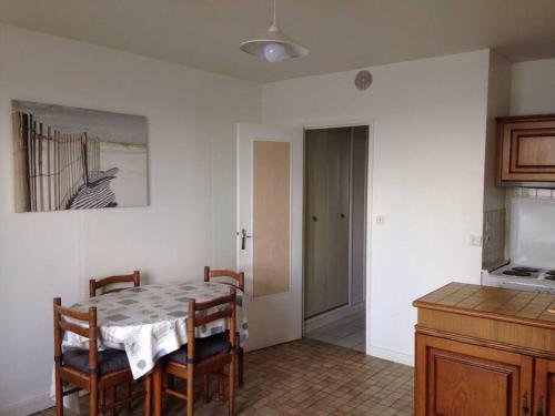 une salle à manger avec une table et des chaises et une cuisine dans l'établissement F2 et JARDINET FACE ET ACCES DIRECT MER, à Bernières-sur-Mer