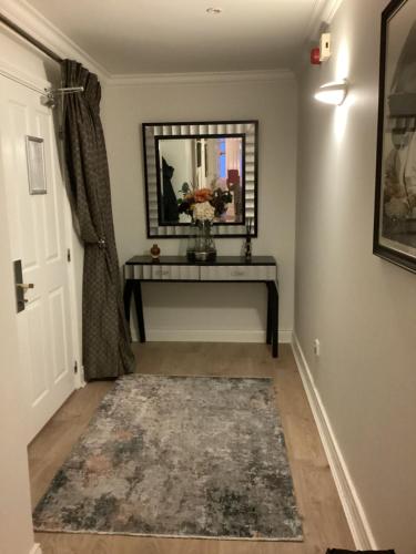 a hallway with a mirror and a table with a rug at Flesk River 22 in Killarney