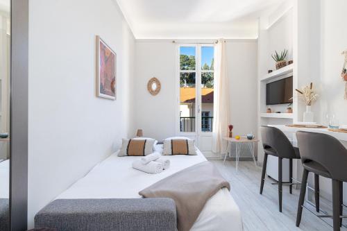 - une chambre blanche avec un lit et une table à manger dans l'établissement 1 GAUTIER 501 - Studio boheme - Quartier du port, à Nice