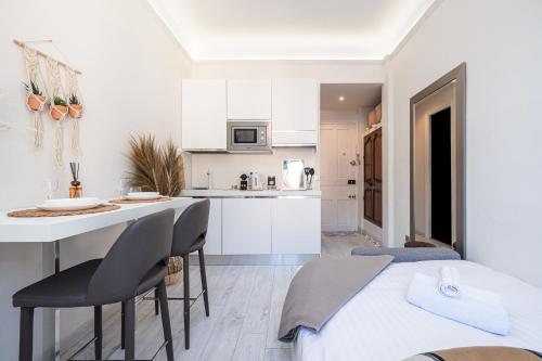 - une cuisine blanche avec un lit, une table et des chaises dans l'établissement 1 GAUTIER 501 - Studio boheme - Quartier du port, à Nice