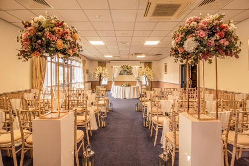 a banquet hall with tables and chairs and flowers at Meon Valley Hotel, Golf & Country Club in Shedfield