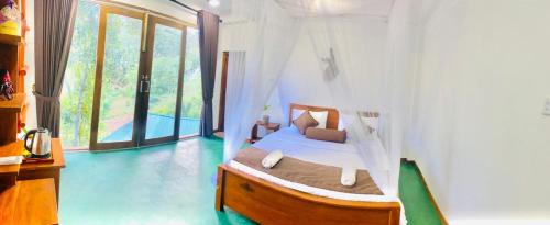 a bedroom with a bed in a room with a window at Serenity cottage in Ella