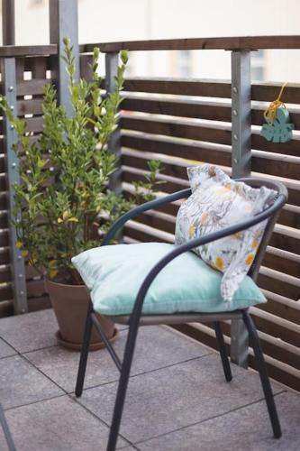 a chair with a pillow on a patio at Beautiful apartment old town Arkadenhof in Löbau